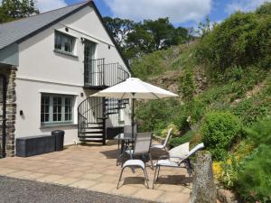a patio with a table and chairs and an umbrella at 1 Bed in Launceston 86674 in North Petherwin