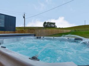 Llanbadarn-fynyddにある4 Bed in Llandrindod Wells 86118の庭にある青い水が入ったジャグジー浴槽