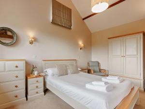 a bedroom with a white bed and a chair at 3 Bed in Launceston 57287 in Launceston