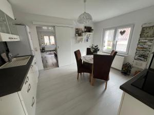 eine Küche und ein Esszimmer mit Tisch und Stühlen in der Unterkunft Villa Wohli 4 Sterne FERIENWOHNUNG AM HARZ in Nordhausen + 21 Fotos