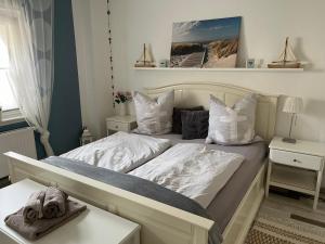 ein Schlafzimmer mit einem Bett mit weißen Laken und Kissen in der Unterkunft Villa Wohli 4 Sterne FERIENWOHNUNG AM HARZ in Nordhausen