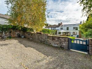 a stone retaining wall with a blue fence in front of a house at 4 bed in Crickhowell 85242 in Crickhowell