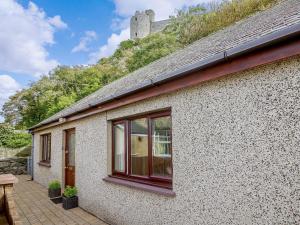 a building with windows and a castle in the background at 4 Bed in Harlech 89631 in Harlech