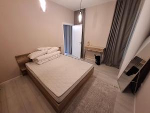 a small bedroom with a bed and a window at Apartment for rent in Mitrovica town centre in Mitrovicë
