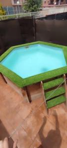a green table with a pool in a backyard at Chalet adosado Anayet in Sabiñánigo