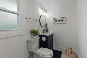 a white bathroom with a toilet and a mirror at The American House in Williams Bay in Lake Geneva +33 photos