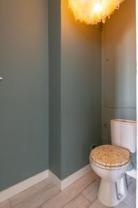 a bathroom with a toilet and a chandelier at Relaxation near Paris in Saint-Denis
