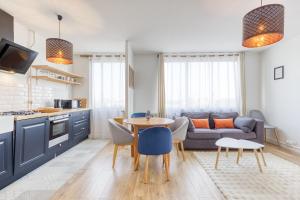 a kitchen and living room with a couch and a table at Relaxation near Paris in Saint-Denis
