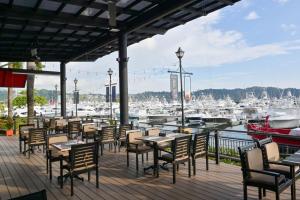 un patio avec des tables et des chaises ainsi qu'un port de plaisance dans l'établissement Del Mar 4M 3 bdr Garden View in Los Suenos, à Isla Herradura