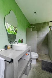 a bathroom with a sink and a mirror and a toilet at Casa del Árbol a 700 metros de Playa Santa Teresa in Santa Teresa Beach