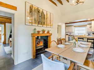 a dining room with a table and a fireplace at 3 Bed in Kirriemuir 96317 in Logie
