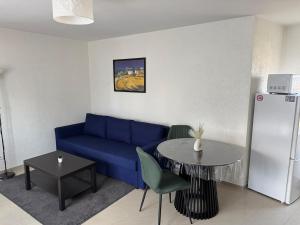 een woonkamer met een blauwe bank en een tafel bij EJolie in Illzach