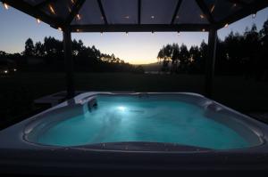 a hot tub under a gazebo with the sunset in the background at Cabanas Da Barcela in Barreiros