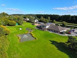 an overhead view of a golf course with a pond at Forest Hills Golf Club in Coleford