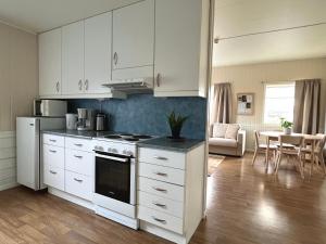 a kitchen with white cabinets and a stove top oven at Tanabrew in Tana