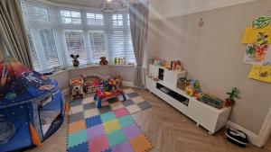 a childs room with a crib and toys in it at Birkdale Open - modern 3 bedroom family home in Ainsdale