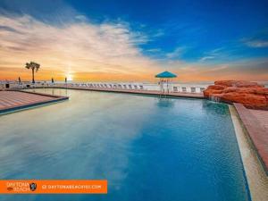 una gran piscina junto a una playa con el océano en Amazing Studio Steps Away From The Atlantic Ocean!, en Daytona Beach