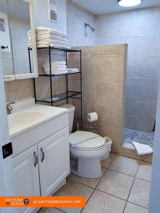 Un baño con inodoro, lavabo y ducha. en Amazing Studio Steps Away From The Atlantic Ocean!, en Daytona Beach