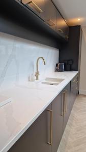 a kitchen with a white counter top and a sink at Birkdale Open - modern 3 bedroom family home in Ainsdale +25 photos