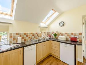 Llandderfelにある1 bed property in Bala North Wales 83765のシンクと壁に時計が付いたキッチン +6枚の写真