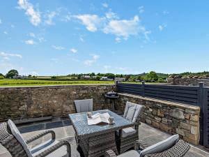 カートメルにある2 bed in Cartmel 89206の石壁のパティオ(テーブル、椅子付)