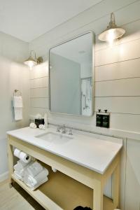 une salle de bain avec un lavabo et un miroir dans l'établissement Rod 'N' Reel Resort, à Chesapeake Beach