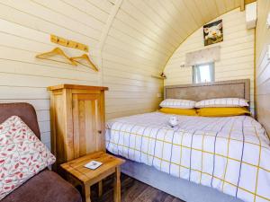 Un pequeño dormitorio con una cama y una silla. en 1 Bed in Hereford 81292, en Aconbury