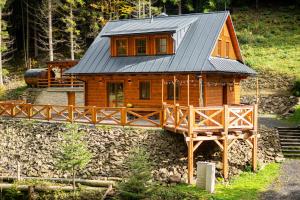 a wooden house with a metal roof on a bridge at Wellness Chalupa Krajanka in Nový Hrozenkov