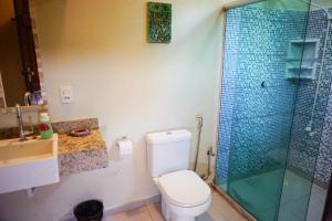 a bathroom with a toilet and a glass shower at Barra Quintal Studio 3 in Barra Grande