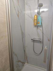 a shower with a glass door and a bottle of soap at Chambre équipée pour 2p in Ostend +3 photos