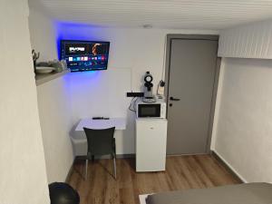 a small room with a table and a tv on the wall at Chambre équipée pour 2p in Ostend +3 photos