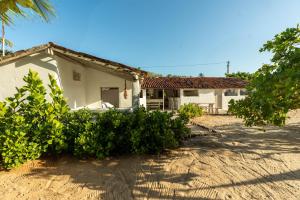a white house with bushes in front of it at TATAJUBA-Casa-de-loulous in Tatajuba