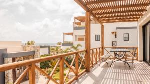 Un balcón con mesa y vista al mar. en The Garden Suite, en El Rebalse
