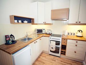 a kitchen with white cabinets and a white stove top oven at 1 bed in Crickhowell 42953 in Llangattock