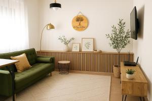 赫雷斯-德拉弗龙特拉El Olivar de Baro的客厅里有一张绿色的沙发和一张桌子