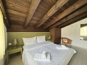 a bedroom with a large bed with a wooden ceiling at Casa Laret 6-12 in Laax-Murschetg