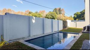 a swimming pool in a yard next to a fence at LiFa Luxury Sandton Retreat in Johannesburg