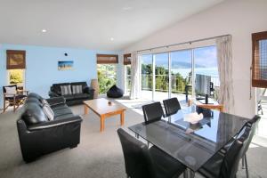 a living room with a couch and a table at Mokorau Apartments - The Mukies in Ahipara