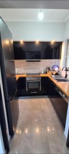 a kitchen with a stainless steel refrigerator and a sink at Eleusis modern flat,carpark in in Elefsina
