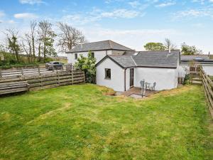 a white house with a fence and a yard at 1 Bed in Portreath OLDML in Camborne