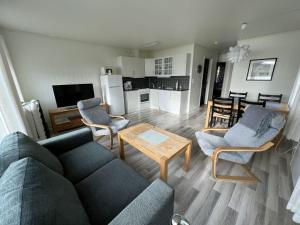 een woonkamer met een bank, stoelen en een tafel bij Arctic Wonderland in Senja
