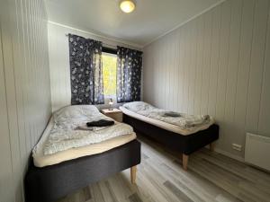 two twin beds in a room with a window at Arctic Wonderland in Senja