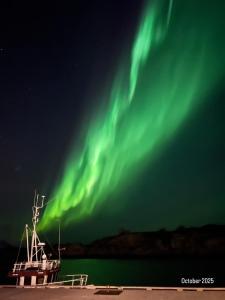 SennesvikにあるLofoten Sea Lodgeの水上のボートの上のオーロラ