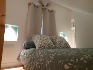 a bedroom with a bed with two pillows and a window at L'ANEDA Vue sur mer - COCCONING 2 Personnes - 3ème étage in Mers-les-Bains
