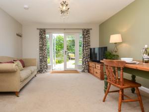 グレート・トーリントンにある1 Bed in Great Torrington 89636のリビングルーム(ソファ、デスク、テレビ付)