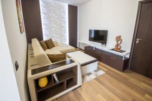 un piccolo soggiorno con divano e TV di City Apartments La Casa a Varna