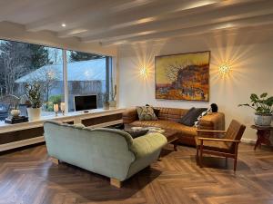 a living room with two couches and a tv at A little piece of heaven in Laugaras