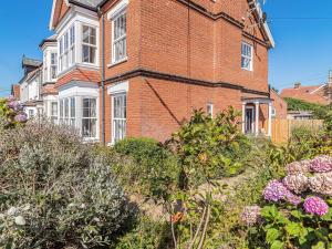 a large brick building with white windows and bushes at 3 bed property in Overstrand KT178 in Overstrand