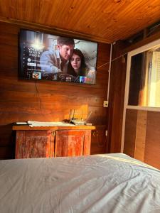 Un dormitorio con un televisor de pantalla plana en la pared. en Casa da Árvore, en Foz do Iguaçu