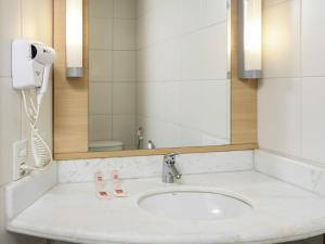 a bathroom with a sink and a mirror at ibis Recife Boa Viagem in Recife +94 photos